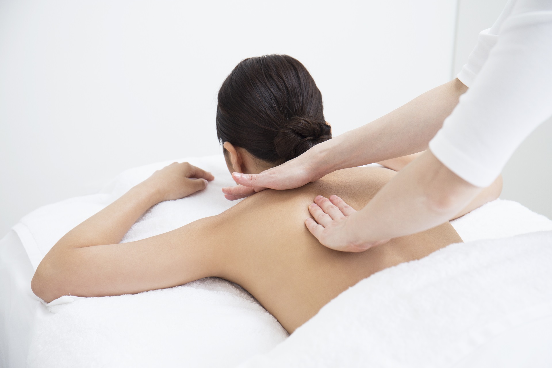 Carolina Pintos Therapy – Relax Massage Therapist performing gentle full body massage on a client lying face down at a Houston clinic