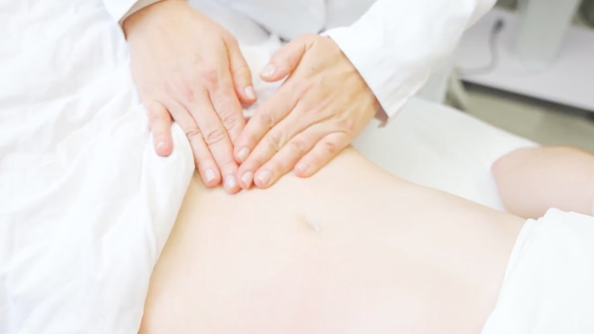 Therapist performing manual lymphatic drainage on a patient’s abdomen after a tummy tuck at Carolina Pintos Therapy in Houston