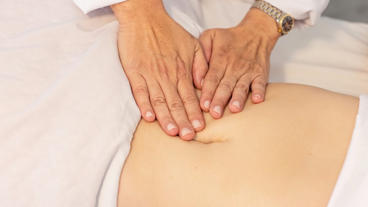 Mommy makeover recovery abdominal lymphatic massage in Houston Therapist performing gentle abdominal lymphatic drainage on a patient recovering from a mommy makeover